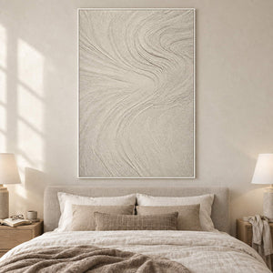 Ivory relief painting with fine flowing wave-like ridges in a white frame in a bedroom.