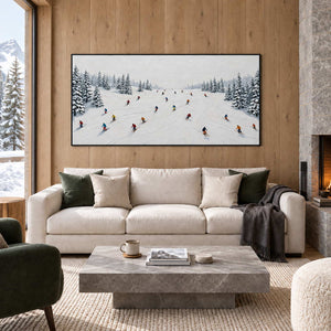 Winter Joy in a black frame above a cream sofa with green cushions and a gray stone coffee table beside a fireplace.