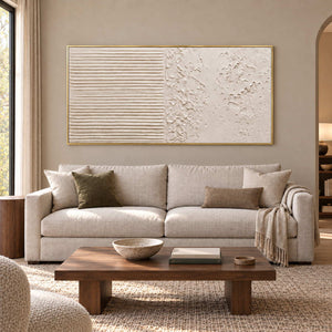 Wordless Dialogue in a gold frame above a cream sofa with olive and taupe cushions and a rectangular wood table.