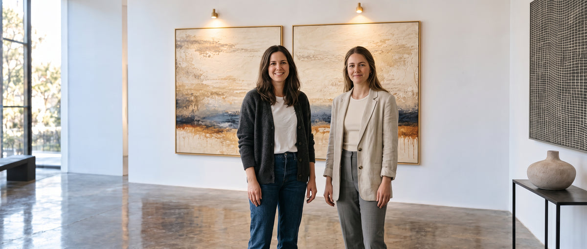 Three design professionals standing in front of a large abstract painting