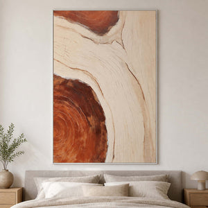 White framed flowing abstract artwork above a bed with layered neutral linens.