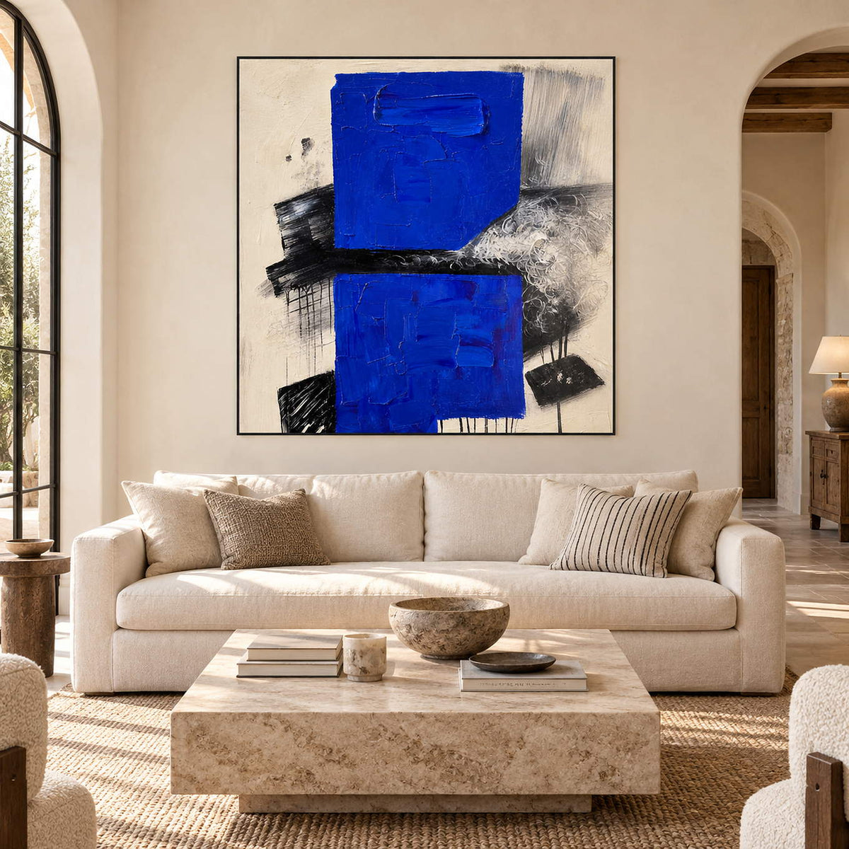 Square cobalt blue, black, and ivory textured abstract painting, displayed in a living room without an outer frame.