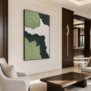 Green abstract artwork overlooking cream lounge chairs and a hotel lobby coffee table.