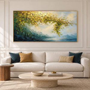 Golden foliage and misty blue water landscape painting in a gold frame in a living room.