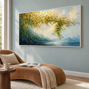 Golden foliage and misty blue water landscape painting in a white frame in a lounge.