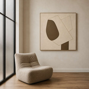 Minimalist cream canvas beside a sculptural chair in a reading nook.