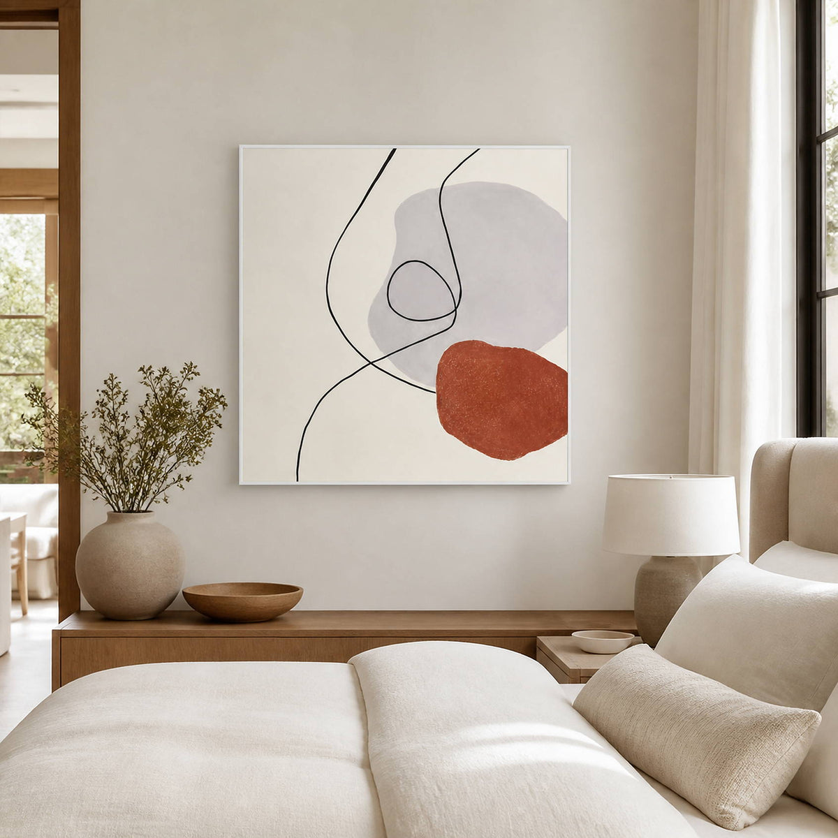Light-framed line artwork beside a cream bed and bedside lamp.