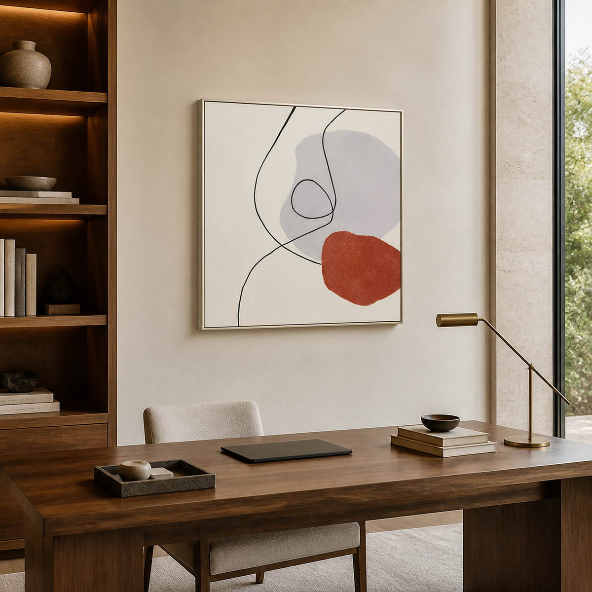 Looping-line artwork above a desk beside illuminated bookshelves.