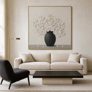 Textured white floral wall art displayed in a minimalist living room.