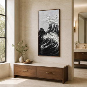 Wood framed black and white wave artwork beside cabinetry in a bathroom dressing area.