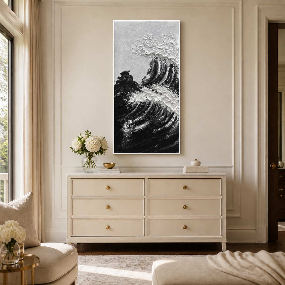 White framed monochrome coastal artwork with textured foam above a pale bedroom dresser.