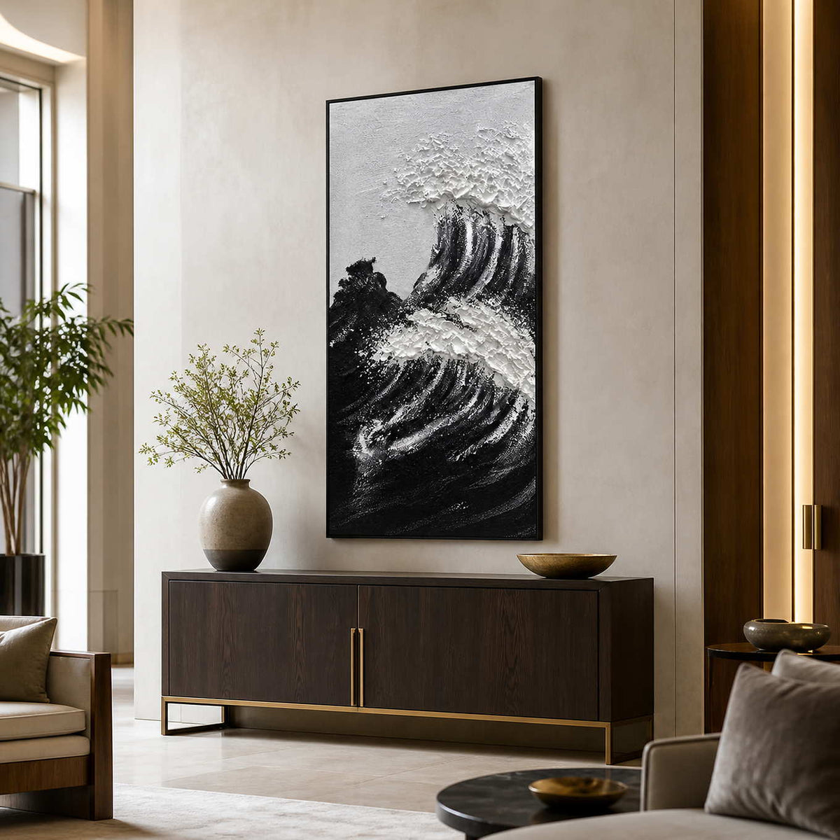 Black framed textured wave painting above a dark console in a bright hotel lobby.