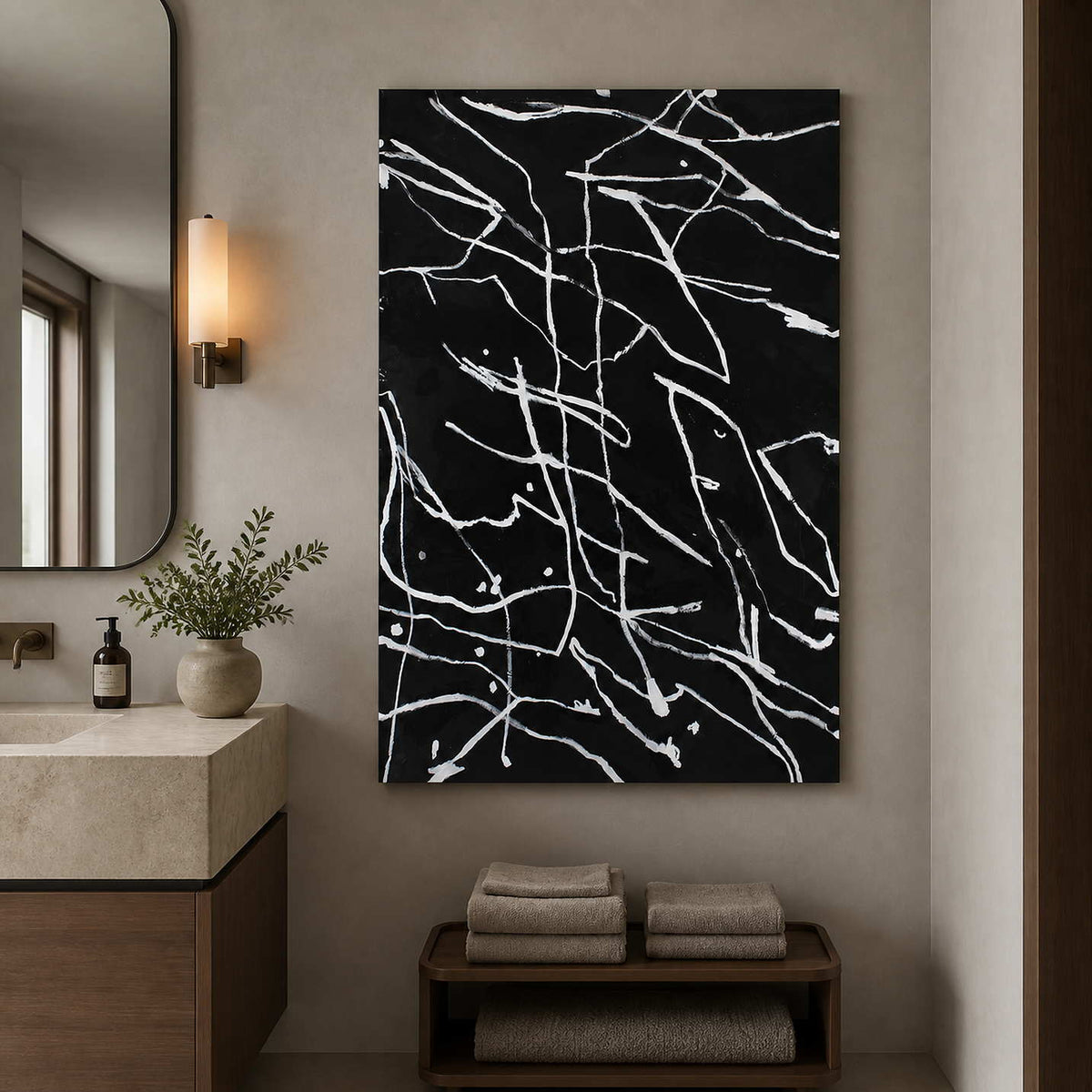 Frameless black and white abstract painting beside a bathroom vanity and mirror.