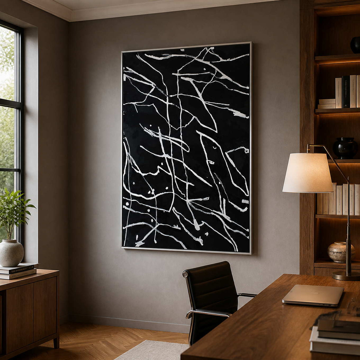 Silver framed abstract line painting behind a wooden desk in a study.