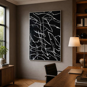 Silver framed abstract line painting behind a wooden desk in a study.
