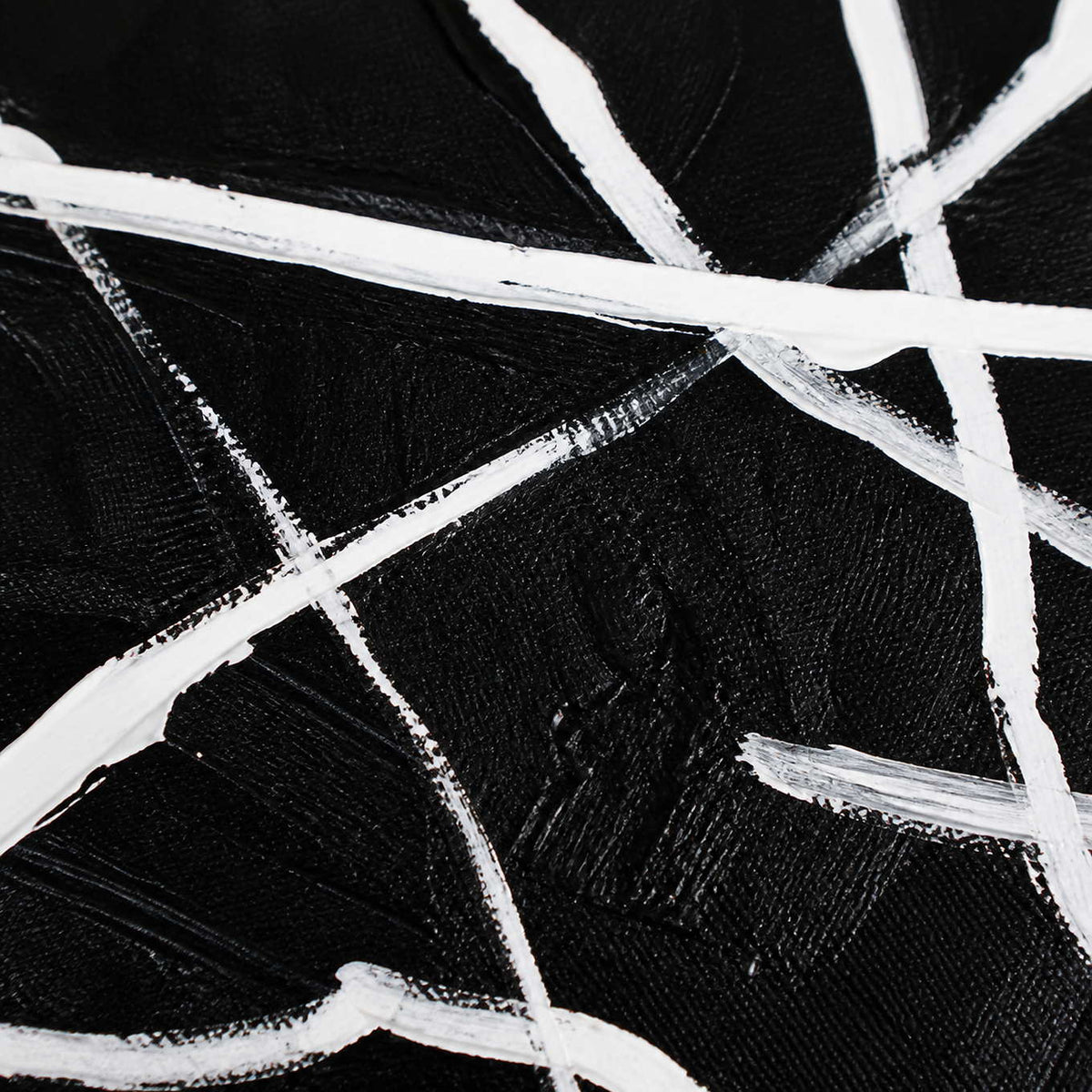 Close up of crossing white brushstrokes and visible canvas weave on black paint.