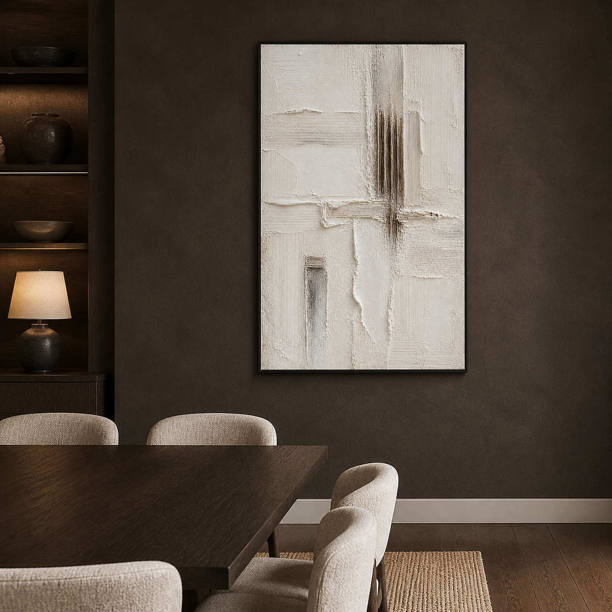 Neutral relief artwork creating contrast in a dark modern dining room.