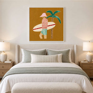 White-framed surfer artwork above a pale bed with muted green pillows and throw.