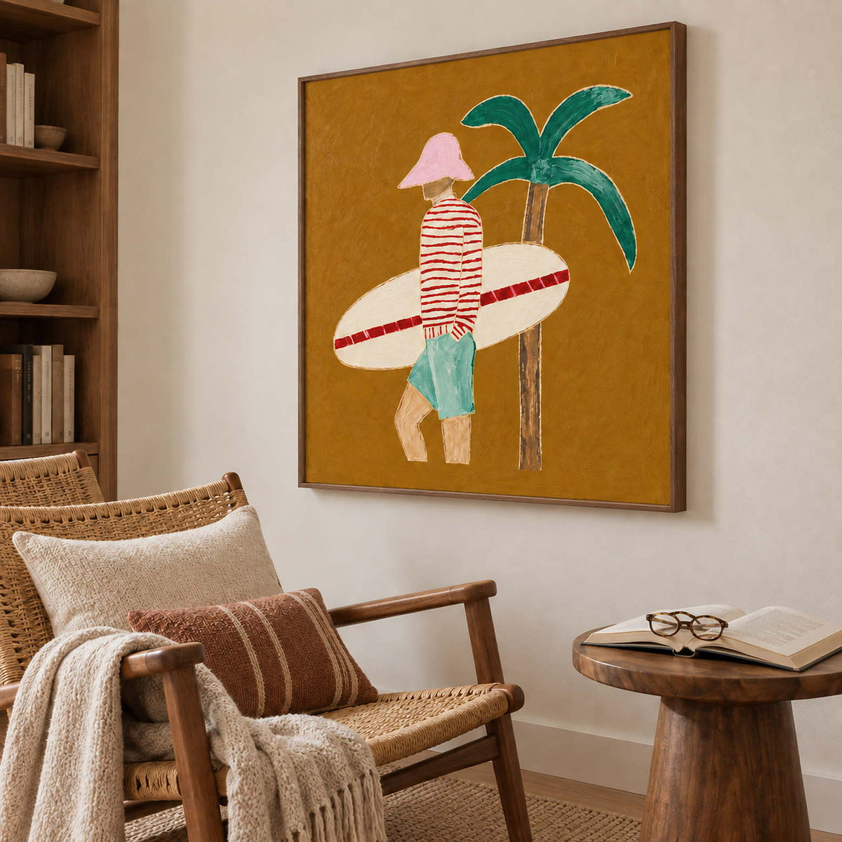 Surfer artwork beside a woven reading chair with rust-striped cushion and an open book.