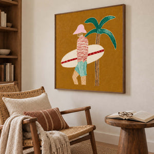 Surfer artwork beside a woven reading chair with rust-striped cushion and an open book.