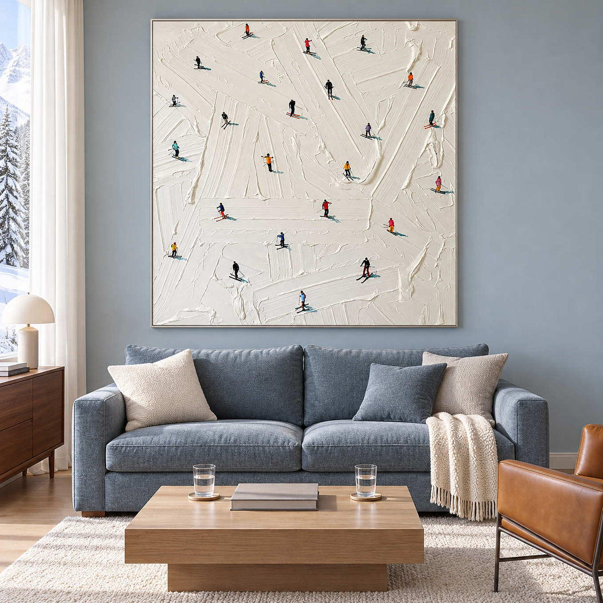 White skiing artwork above a blue sofa near a snowy window view.