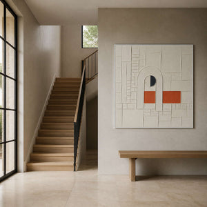 Ivory relief wall art displayed beside a warm travertine entry staircase.