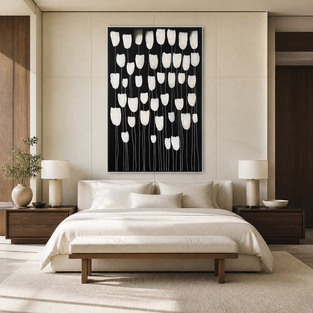 White framed black and white floral artwork above a softly upholstered bed.
