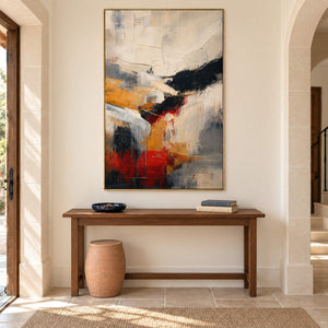 Ivory, ochre and red abstract strokes crossed by bold black bands in a gold frame, displayed in an entrance hall.
