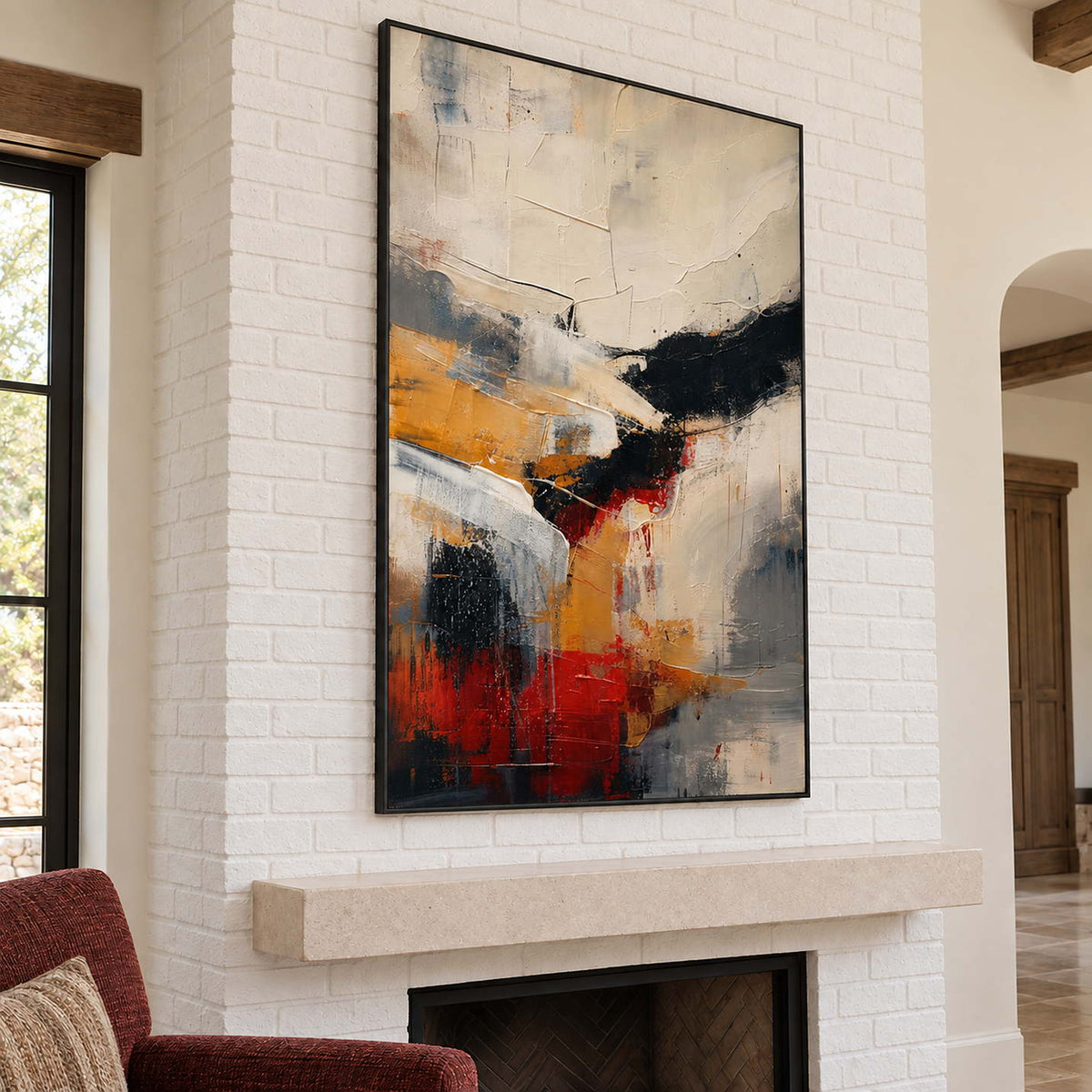 Ivory, ochre and red abstract strokes crossed by bold black bands in a black frame, displayed above a fireplace.