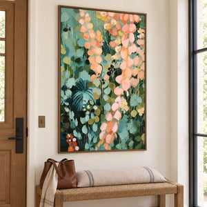 Cascading peach and blush leaves against deep green foliage in a brown wood frame, displayed in an entrance hall.