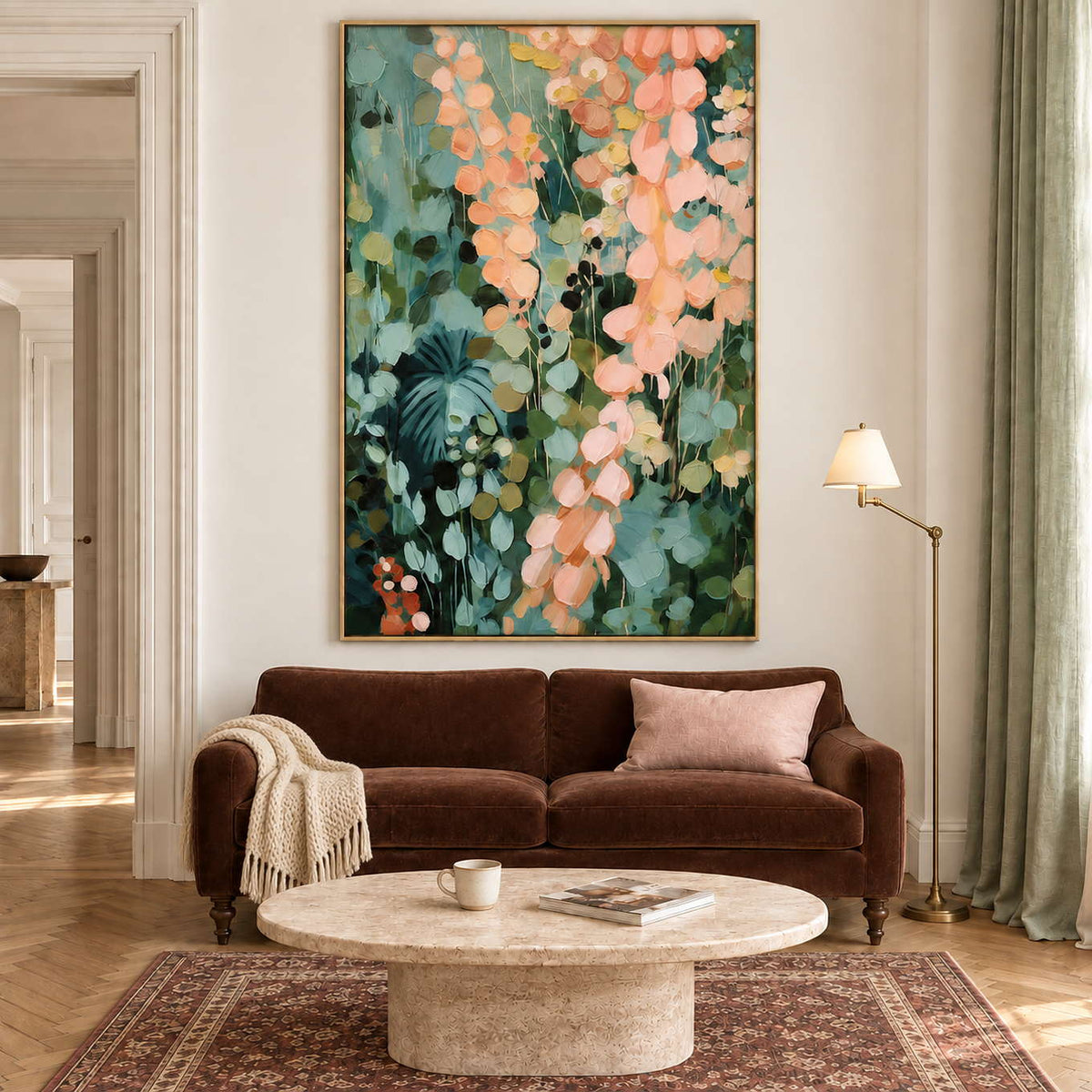 Cascading peach and blush leaves against deep green foliage in a gold frame, displayed above a sofa in a living room.