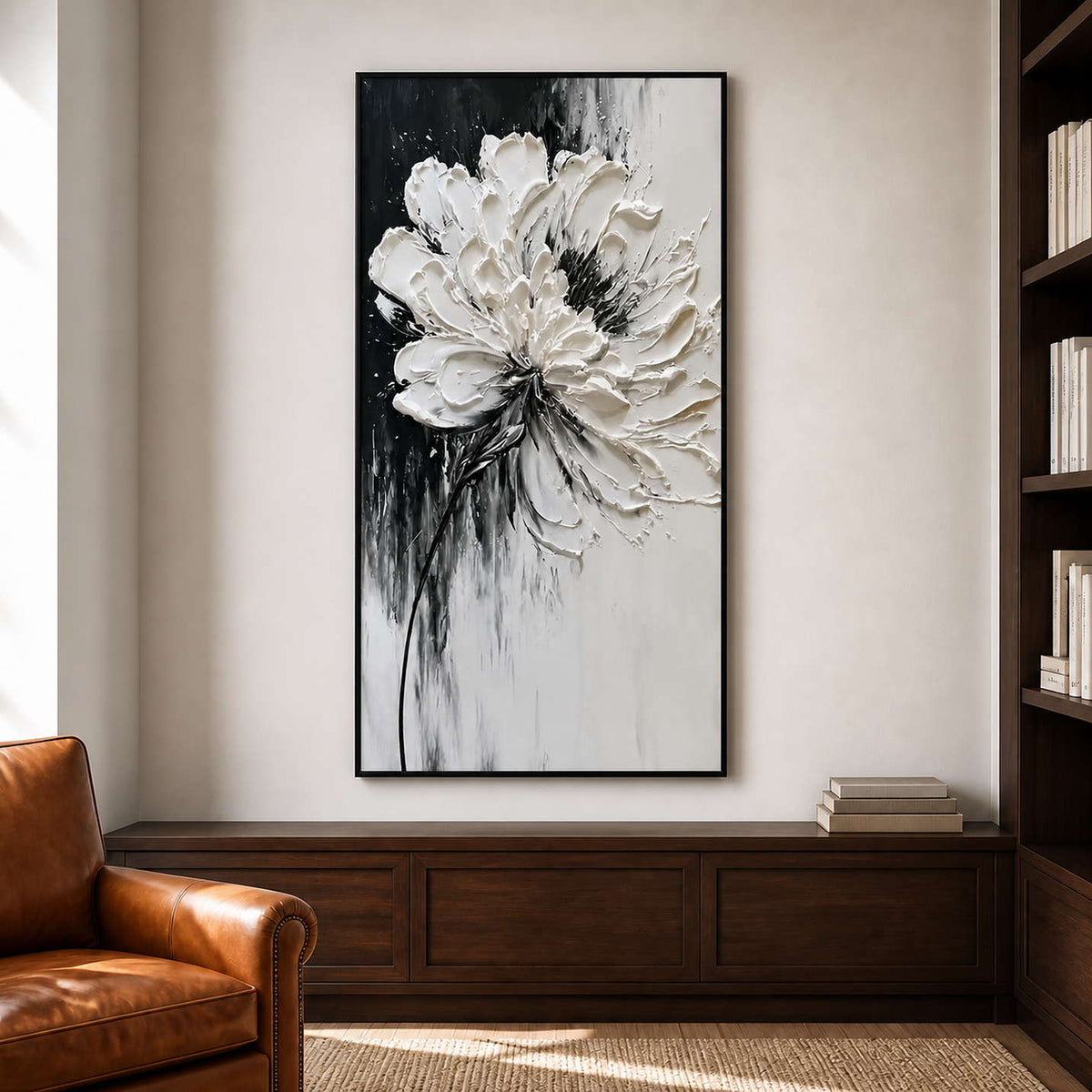 Black framed white floral artwork above walnut cabinets beside a leather reading chair.