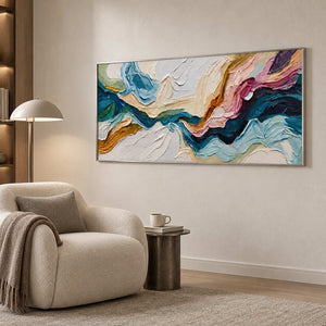 Wide color-sweep artwork beside a rounded cream chair and dome-shade reading lamp.