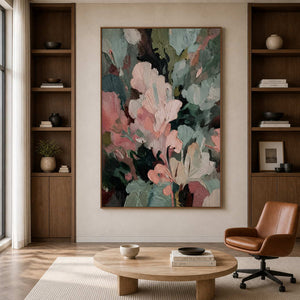 Wood framed textured artwork beside bookshelves and a leather chair in an office reading corner.