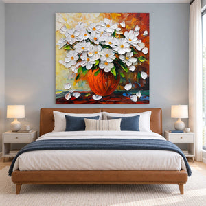 White bouquet painting above a tan bed with navy bedding.