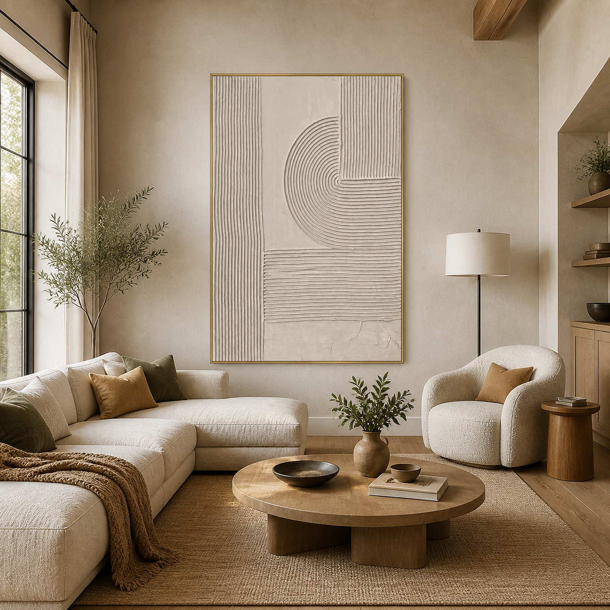 Gold framed beige relief artwork above soft living room seating and a round table.