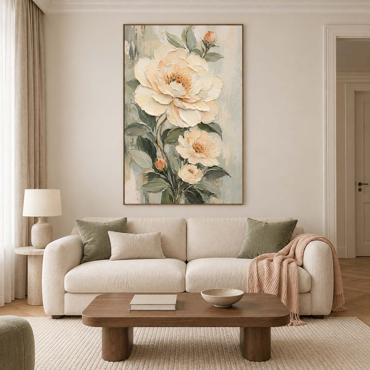 Cream flowers and soft green leaves on a muted background in a brown wood frame, displayed above a sofa in a living room.