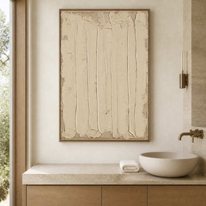 Wood framed cream textured painting beside a stone bathroom vanity.