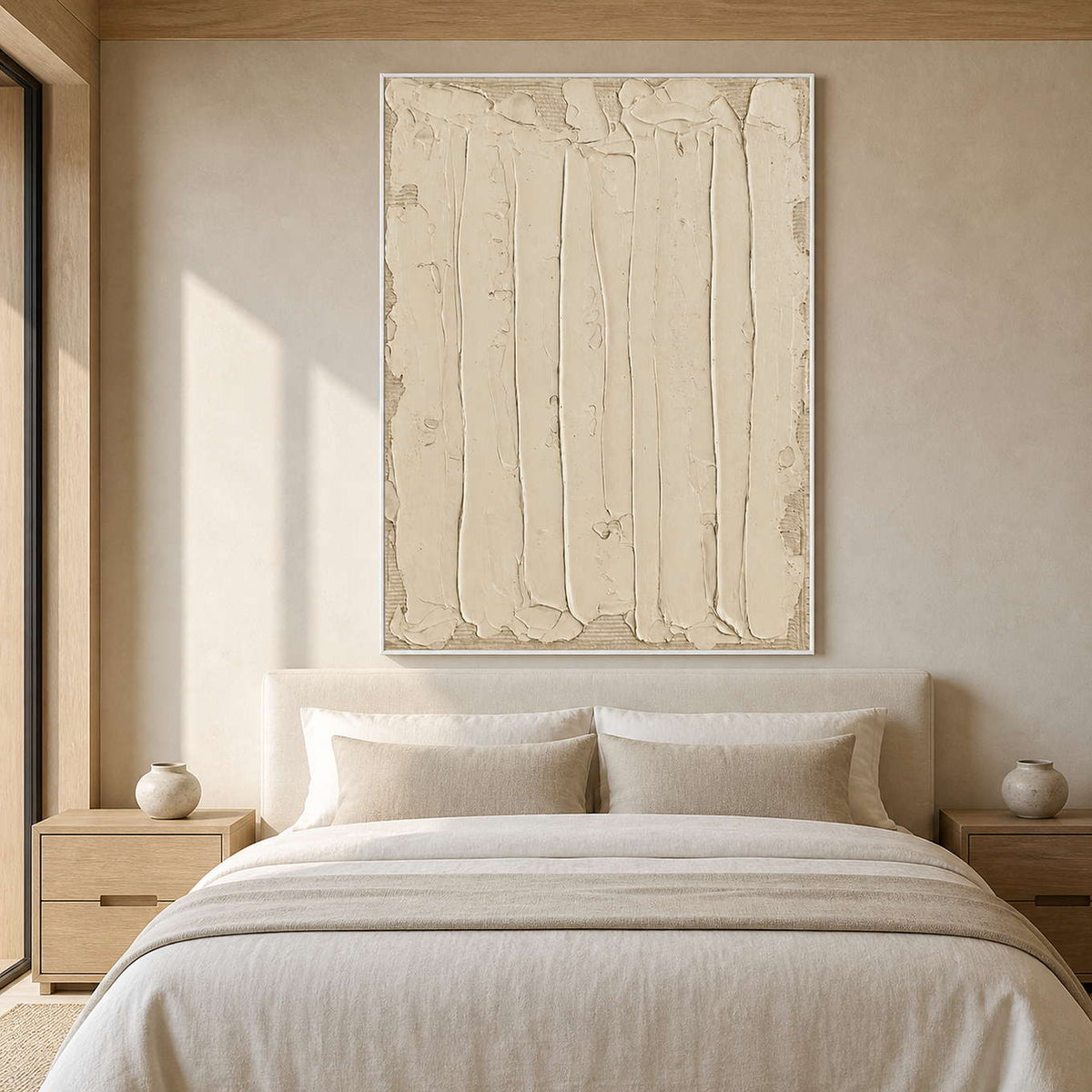 White framed cream abstract artwork above an upholstered bed with neutral linens.