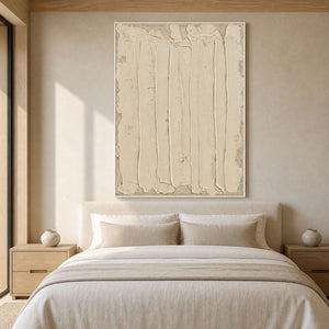 White framed cream abstract artwork above an upholstered bed with neutral linens.