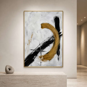 Black white and gold abstract wall art displayed in a gallery reception.