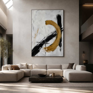 Black and gold abstract wall art displayed in a double-height modern living room.