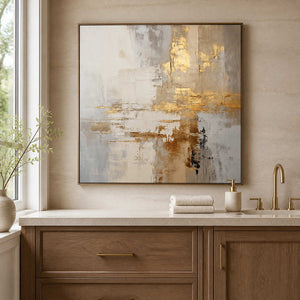 Wood framed cream and gold artwork above a vanity in a bathroom dry area.