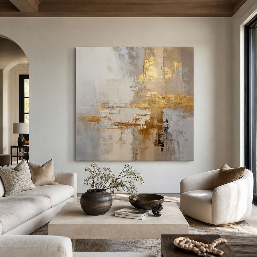 Frameless cream and gold abstract artwork above neutral seating in a bright living room.
