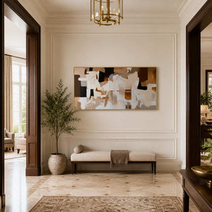 Gold framed cream and brown artwork above a bench in a bright hallway.