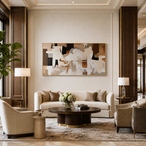 Gold framed wide abstract artwork above cream seating in an elegant hotel lobby.
