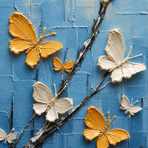 Close-up of raised gold ivory and red butterfly wings over blue texture.