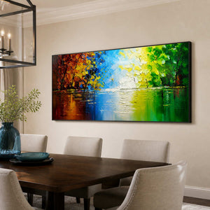 Black-framed lake landscape with bright reflections beside a dark wood dining table.