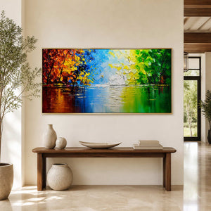 Gold-framed lake painting above a wooden hallway console with pale ceramic vessels.