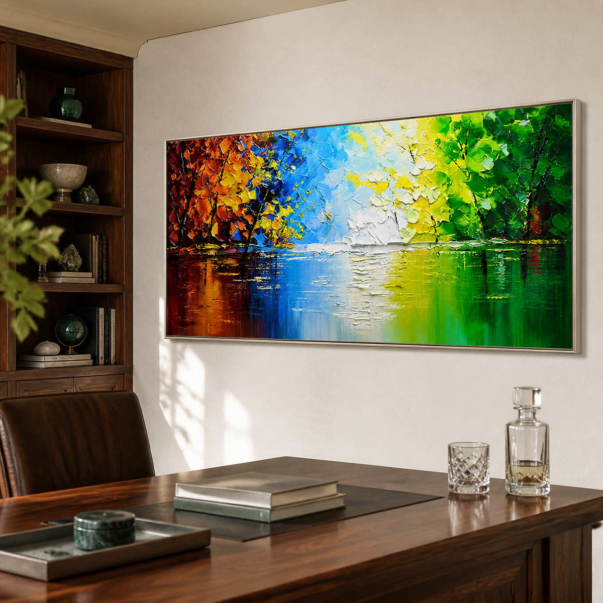 Silver-framed lake landscape with orange and green foliage beside wooden office shelving.